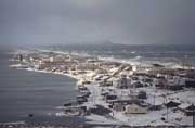 The native community of Uelen is pounded by heavy seas during an autumn storm.Less sea ice in recent years has resulted in more storm damage to the buildings. Chukotka, Siberia, Russia.