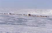 Dolgan reindeer herders move their camp of baloks (huts on sled runners) across a frozen lake during the winter. Taymyr. Northern Siberia, Russia.